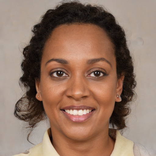 Joyful black young-adult female with medium  brown hair and brown eyes