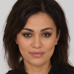 Joyful white young-adult female with long  brown hair and brown eyes