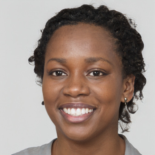 Joyful black young-adult female with short  black hair and brown eyes