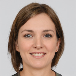 Joyful white young-adult female with medium  brown hair and grey eyes