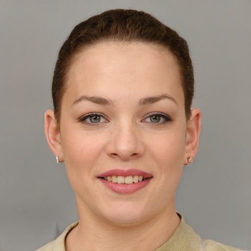 Joyful white young-adult female with short  brown hair and grey eyes