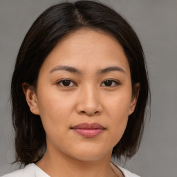 Joyful asian young-adult female with medium  brown hair and brown eyes