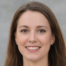 Joyful white young-adult female with long  brown hair and green eyes