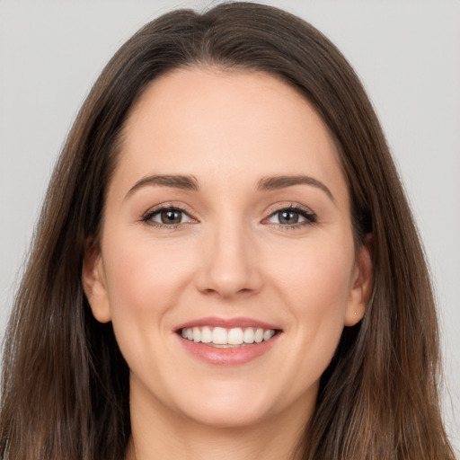 Joyful white young-adult female with long  brown hair and brown eyes