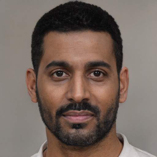 Joyful black young-adult male with short  black hair and brown eyes
