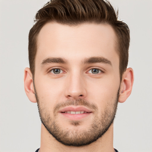 Joyful white young-adult male with short  brown hair and grey eyes