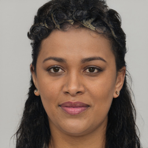 Joyful black young-adult female with long  black hair and brown eyes