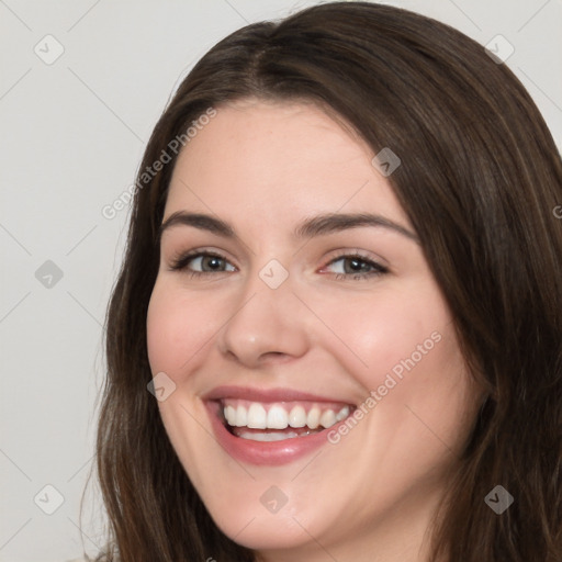 Joyful white young-adult female with long  brown hair and brown eyes