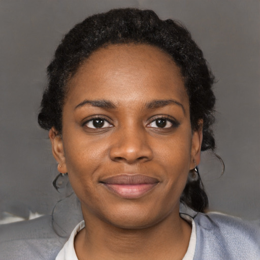 Joyful black young-adult female with short  black hair and brown eyes