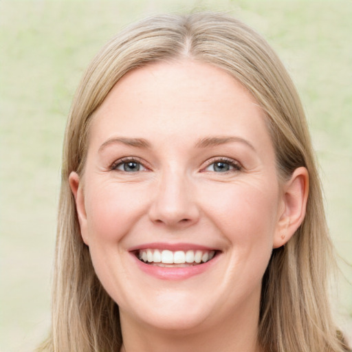 Joyful white adult female with long  brown hair and blue eyes