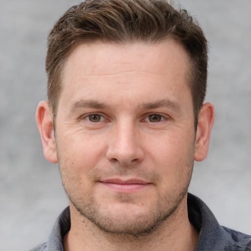 Joyful white adult male with short  brown hair and grey eyes