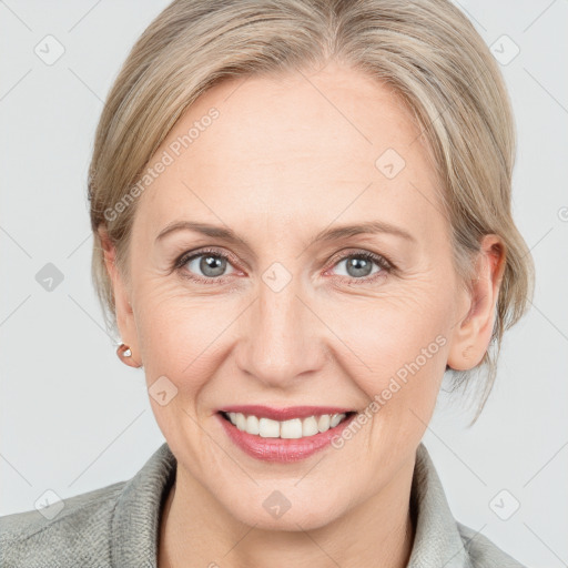 Joyful white adult female with medium  brown hair and blue eyes