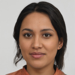 Joyful latino young-adult female with medium  brown hair and brown eyes