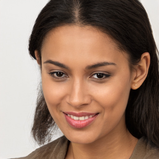 Joyful latino young-adult female with long  brown hair and brown eyes