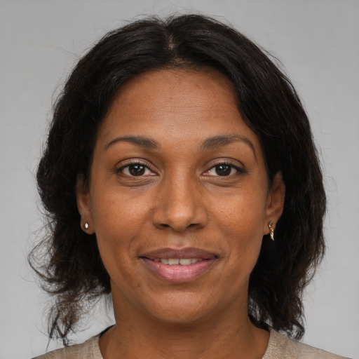 Joyful black adult female with medium  brown hair and brown eyes