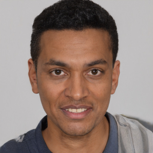 Joyful black young-adult male with short  black hair and brown eyes