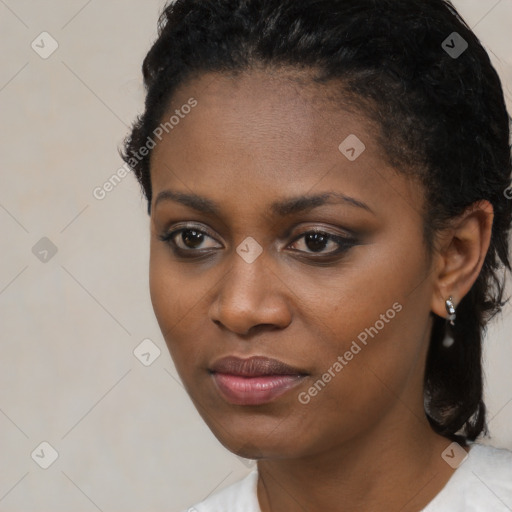 Joyful black young-adult female with short  black hair and brown eyes