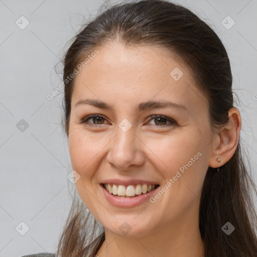 Joyful white young-adult female with long  brown hair and brown eyes