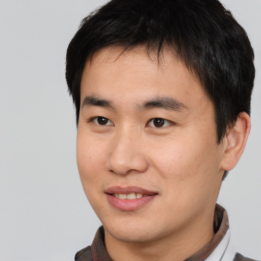 Joyful asian young-adult male with short  black hair and brown eyes