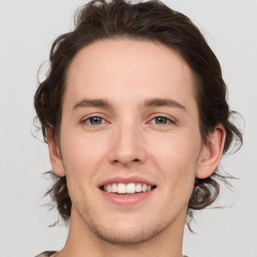 Joyful white young-adult male with medium  brown hair and brown eyes