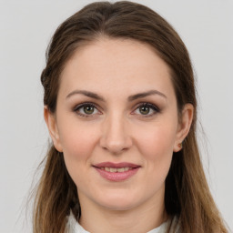 Joyful white young-adult female with long  brown hair and grey eyes