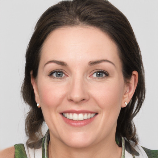 Joyful white adult female with medium  brown hair and grey eyes