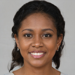 Joyful black young-adult female with medium  brown hair and brown eyes