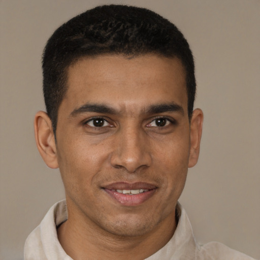 Joyful latino young-adult male with short  brown hair and brown eyes