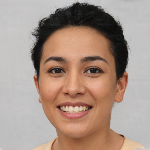 Joyful latino young-adult female with short  brown hair and brown eyes