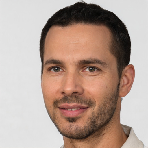 Joyful white young-adult male with short  black hair and brown eyes