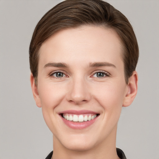 Joyful white young-adult female with short  brown hair and grey eyes