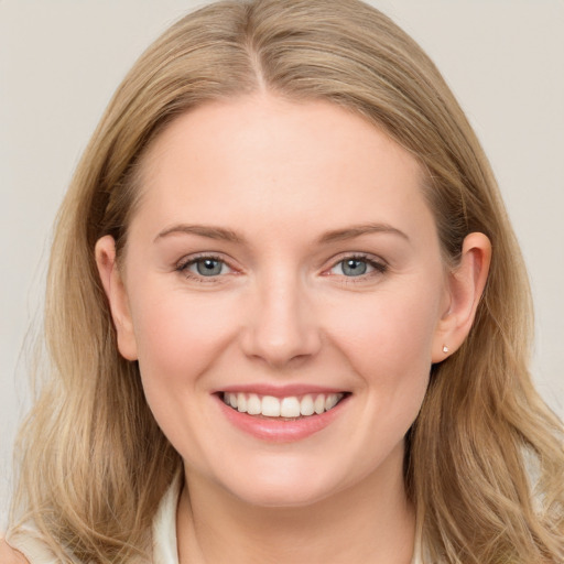 Joyful white young-adult female with long  brown hair and blue eyes