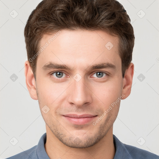 Joyful white young-adult male with short  brown hair and grey eyes