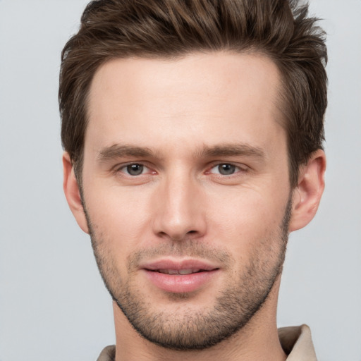 Joyful white young-adult male with short  brown hair and grey eyes