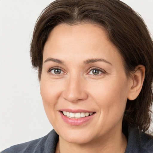 Joyful white adult female with medium  brown hair and grey eyes