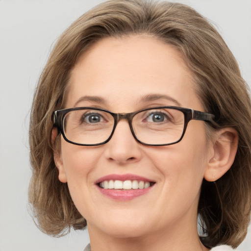 Joyful white adult female with medium  brown hair and blue eyes