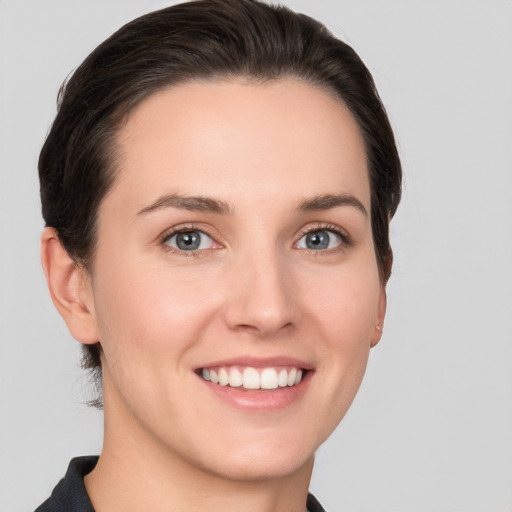 Joyful white young-adult female with short  brown hair and grey eyes