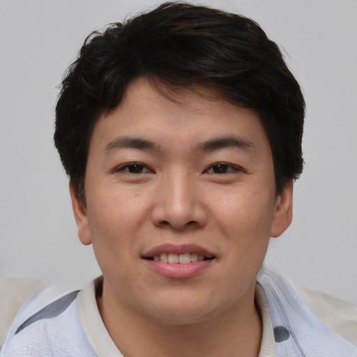 Joyful asian young-adult male with short  brown hair and brown eyes