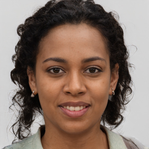 Joyful black young-adult female with long  brown hair and brown eyes