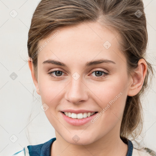 Joyful white young-adult female with medium  brown hair and grey eyes