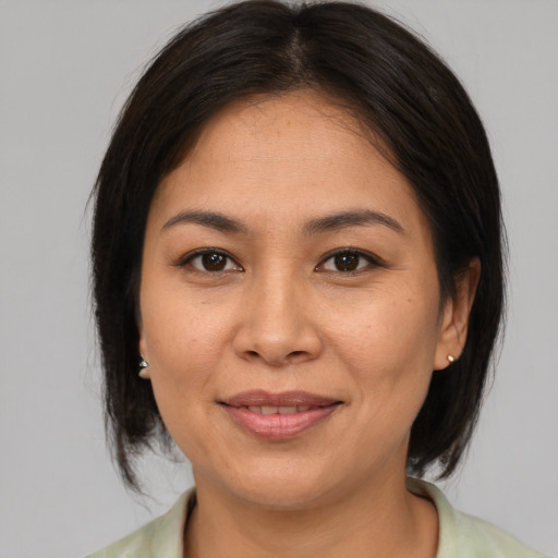 Joyful asian adult female with medium  brown hair and brown eyes
