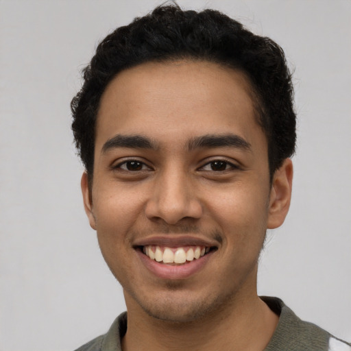 Joyful latino young-adult male with short  black hair and brown eyes