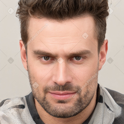 Joyful white young-adult male with short  brown hair and grey eyes