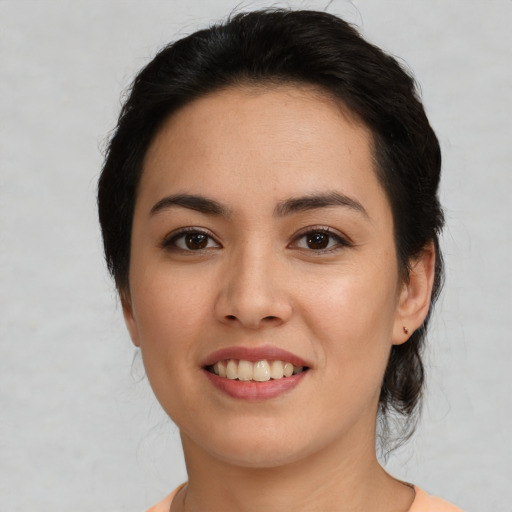 Joyful latino young-adult female with medium  brown hair and brown eyes