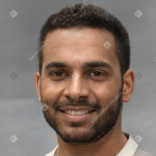 Joyful black young-adult male with short  black hair and brown eyes