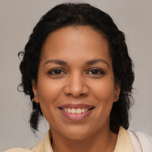 Joyful latino adult female with medium  brown hair and brown eyes