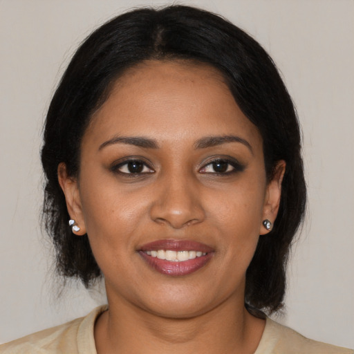 Joyful black young-adult female with medium  black hair and brown eyes