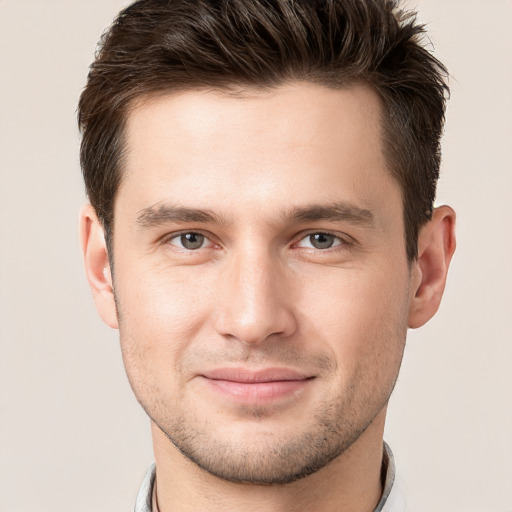 Joyful white young-adult male with short  brown hair and grey eyes