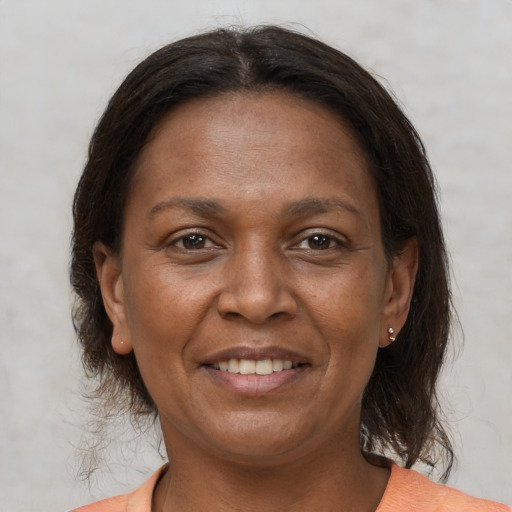 Joyful black adult female with medium  brown hair and brown eyes