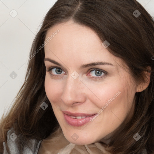 Joyful white young-adult female with long  brown hair and grey eyes